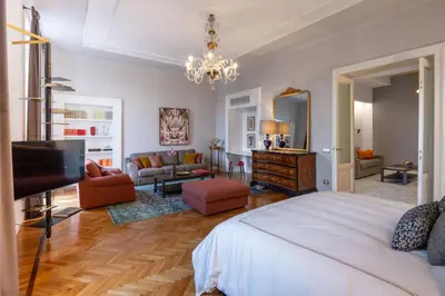 a bedroom with a bed and a living room at Migliori Collection Suites Via Veneto in Rome