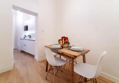 a dining room with a wooden table and white chairs at Casa Trilussa Luxury House with Terrace in Trastevere in Rome