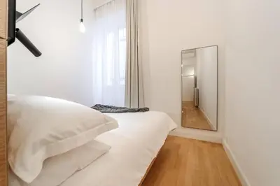 a bedroom with a white bed and a mirror at Casa Trilussa Luxury House with Terrace in Trastevere in Rome