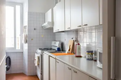 a kitchen with white cabinets and a stove top oven at Via Veneto e La Dolce Vita in Rome