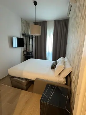 a small bedroom with a bed with white sheets and pillows at NeW!The Place Vaticano 278 guest house in Rome