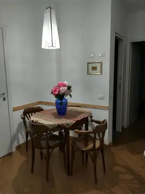 a dining room table with a vase of flowers on it at oreglia house in Rome
