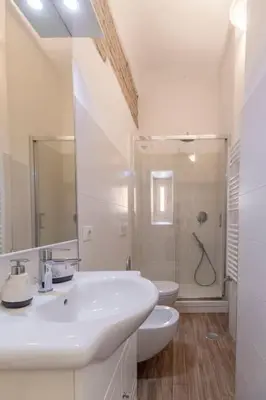 a white bathroom with a sink and a toilet at 2 minutes from the Colosseum - Luxury apartment in Rome