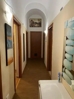 a hallway of a room with a door and some paintings at Stephany's Guesthouse in Rome