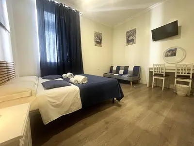 a bedroom with a bed and a chair and a table at Stephany's Guesthouse in Rome