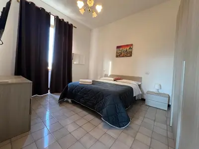a bedroom with a bed with a black comforter at Stephany's Guesthouse in Rome
