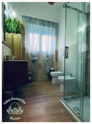 a bathroom with a toilet and a glass shower at Casa Domitilla in Rome