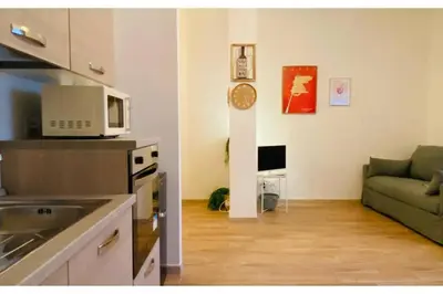a kitchen and a living room with a couch at Casa Domitilla in Rome