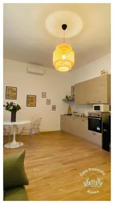 a living room with a table and a kitchen at Casa Domitilla in Rome