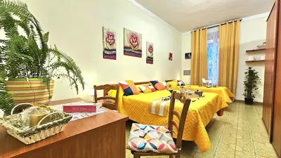 a room with two beds and a table with a plant at A Casa Simpatia Vaticano in Rome