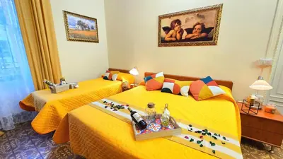 a hotel room with two beds with yellow sheets at A Casa Simpatia Vaticano in Rome