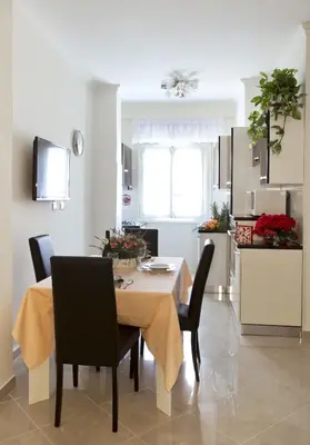 a kitchen and dining room with a table and chairs at Il Bacio Holidayhouse BEST LOCATION FOR VISIT THE VATICAN in Rome