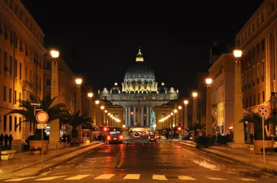 a city street at night with a building in the background at Il Bacio Holidayhouse BEST LOCATION FOR VISIT THE VATICAN in Rome