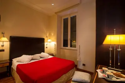 a bedroom with a red bed and a table at Hotel Giolitti in Rome
