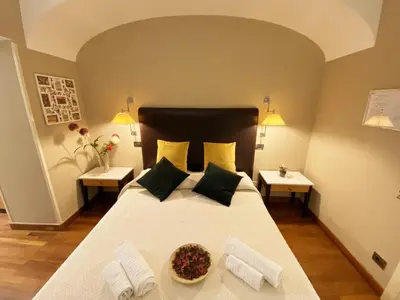 a bedroom with a large white bed with two tables at Hotel Giolitti in Rome