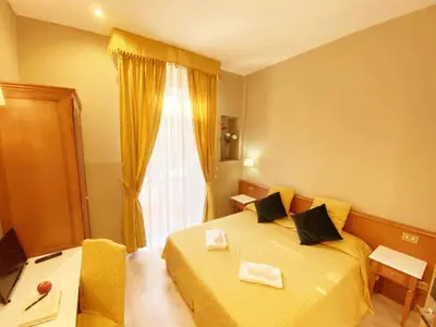 a bedroom with a yellow bed and a window at Hotel Giolitti in Rome