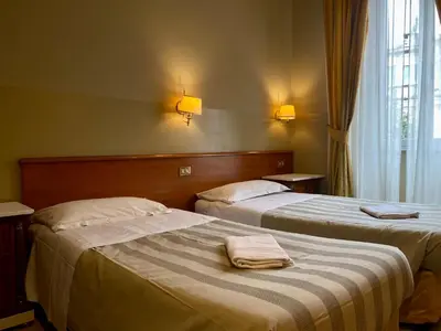 two beds in a hotel room with towels on them at Hotel Giolitti in Rome