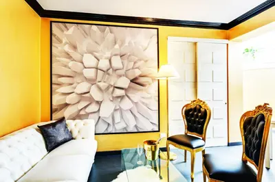a living room with a white couch and a large painting at Spanish Steps Boutique Gold Apartment in Rome