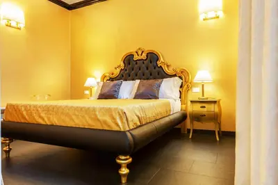 a bedroom with a king sized bed with yellow walls at Spanish Steps Boutique Gold Apartment in Rome