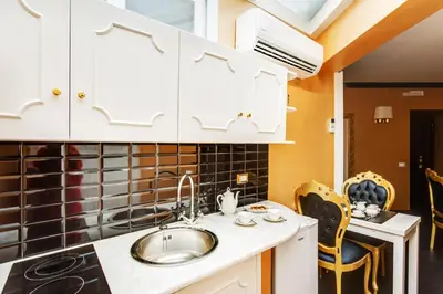 a kitchen with white cabinets and a sink at Spanish Steps Boutique Gold Apartment in Rome