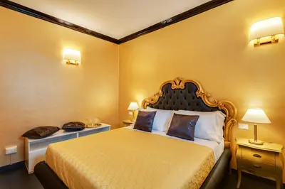 a bedroom with a king sized bed with yellow walls at Spanish Steps Boutique Gold Apartment in Rome