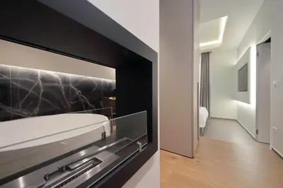 a bathroom with a white tub and a black wall at Roma Suite Major in Rome