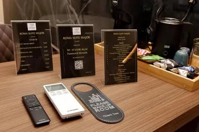 a table with a cell phone and a remote control at Roma Suite Major in Rome
