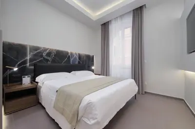 a bedroom with a large bed and a large window at Roma Suite Major in Rome