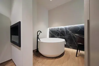 a bathroom with a white tub and a tv at Roma Suite Major in Rome