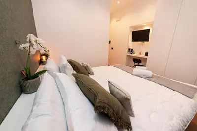 a large white bed with pillows in a room at Il Melograno - Casa Palmeri in Rome
