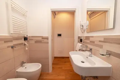 a white bathroom with a sink and a toilet at Il Melograno - Casa Palmeri in Rome
