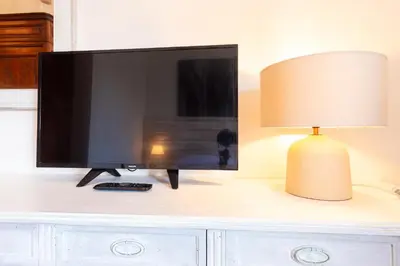a flat screen tv sitting on a desk with a lamp at Sunny Charming 3 BDR, 3BATH Home in Rome