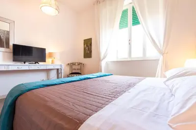 a bedroom with a bed with a television and a window at Sunny Charming 3 BDR, 3BATH Home in Rome