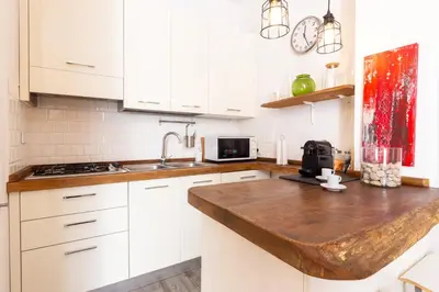a kitchen with white cabinets and a wooden counter top at Sunny Charming 3 BDR, 3BATH Home in Rome