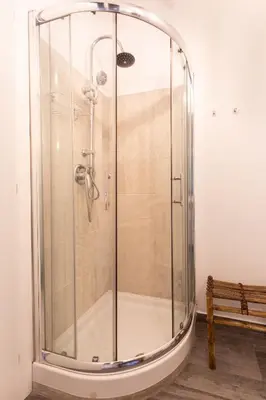 a shower with a glass enclosure next to a bench at Sunny Charming 3 BDR, 3BATH Home in Rome