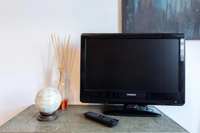 a television sitting on a table with a remote control at Sunny Charming 3 BDR, 3BATH Home in Rome