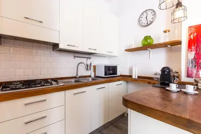 a kitchen with white cabinets and a sink at Sunny Charming 3 BDR, 3BATH Home in Rome