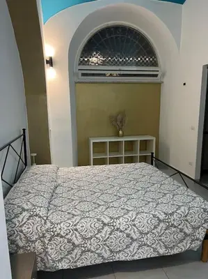 a bedroom with a bed with a white comforter at Fenty Home 2 San Lorenzo in Rome