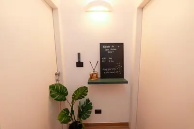 a chalkboard on a wall next to a plant at Il Mandorlo - Casa Palmeri in Rome