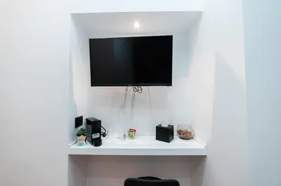 a flat screen tv hanging on a white wall at Il Mandorlo - Casa Palmeri in Rome