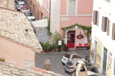 an alley with cars parked in front of buildings at Magic Trastevere suite on roof terrace in Rome
