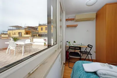 a room with a bed and a balcony with a table at Magic Trastevere suite on roof terrace in Rome