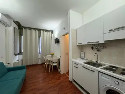 a kitchen with a sink and a table in a room at San Giovanni's Cozy Apartment in Rome