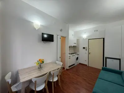 a living room with a dining room table and a kitchen at San Giovanni's Cozy Apartment in Rome