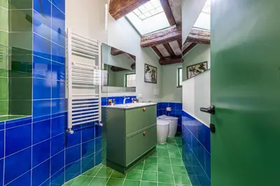 a bathroom with blue and green tiled walls and a window at Elegantis Dimora dell'Architetto in Campo de' Fiori With private terrace in Rome