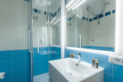 a blue bathroom with a sink and a shower at Elegantis Dimora dell'Architetto in Campo de' Fiori With private terrace in Rome