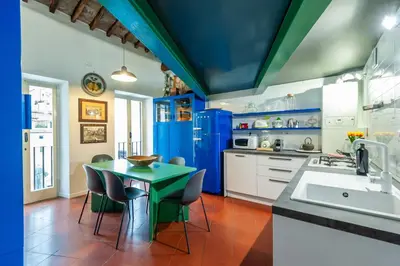 a kitchen with blue walls and a green table and chairs at Elegantis Dimora dell'Architetto in Campo de' Fiori With private terrace in Rome
