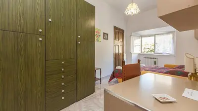 a room with a large green cabinet and a bedroom at Caterina One o One - Embassy Apartment in Rome