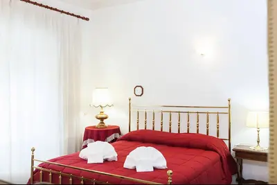 a bedroom with a red bed with two towels on it at Caterina One o One - Embassy Apartment in Rome