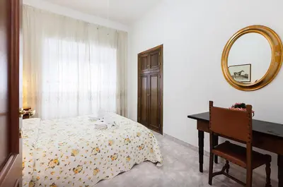 a bedroom with a bed and a mirror and a piano at Caterina One o One - Embassy Apartment in Rome